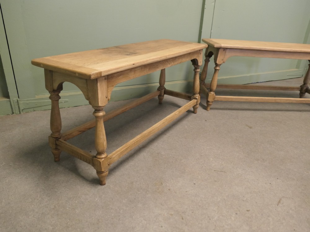 A pair of matching long bleached oak joint benches featuring turned legs, box stretchers, and arched aprons. View V