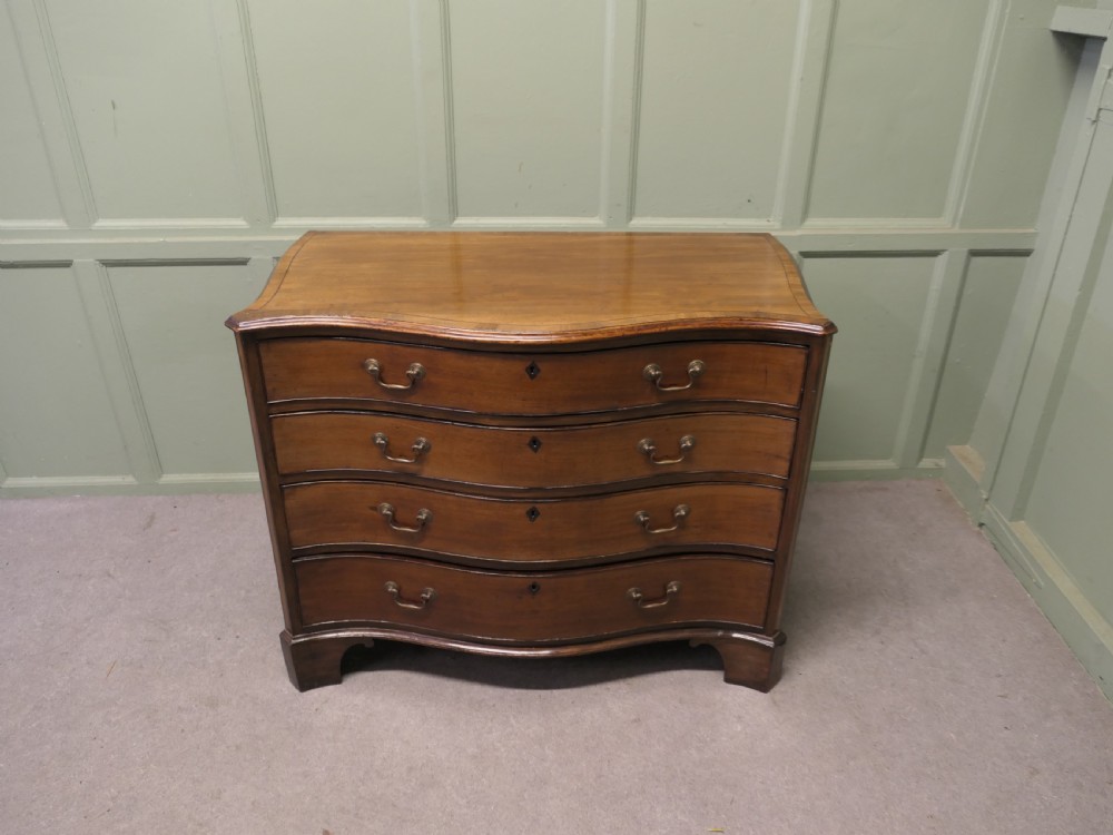 A Georgian serpentine-fronted walnut chest of drawers featuring four graduated drawers with brass swan-neck handles. View III