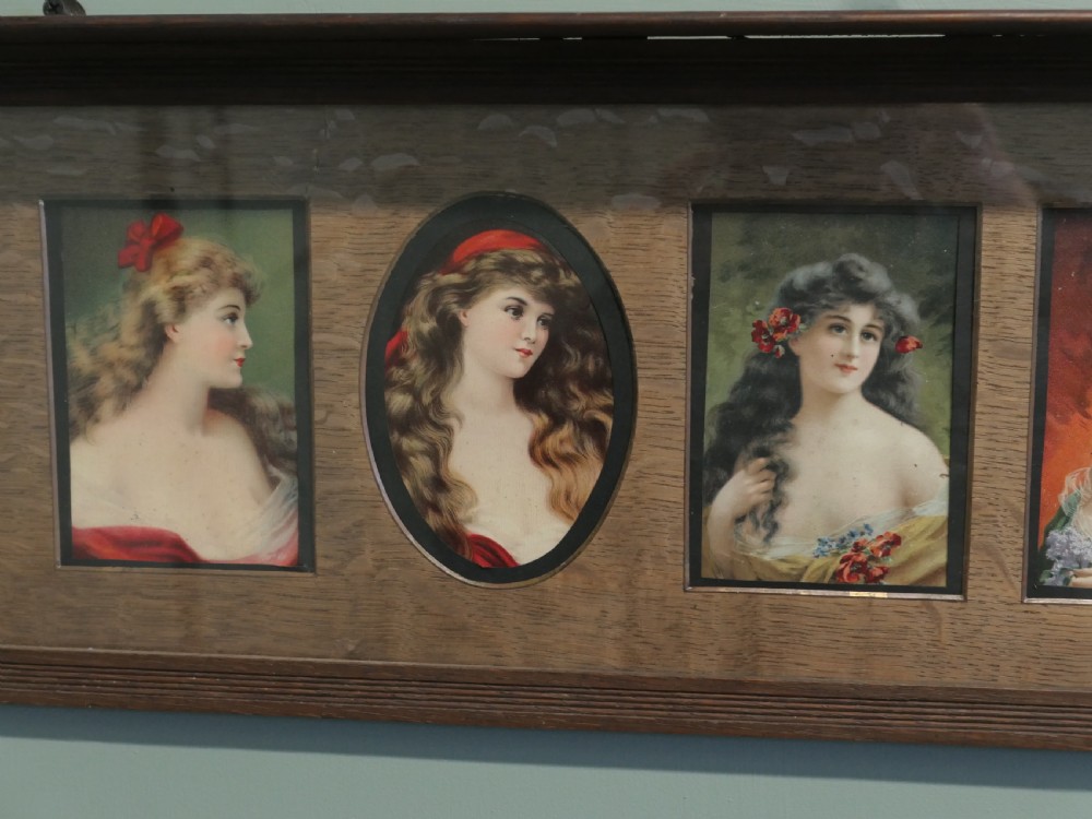 A horizontal dark oak wall shelf featuring six mounted Pre-Raphaelite style female portraits set behind alternating rectangular and oval apertures. View V