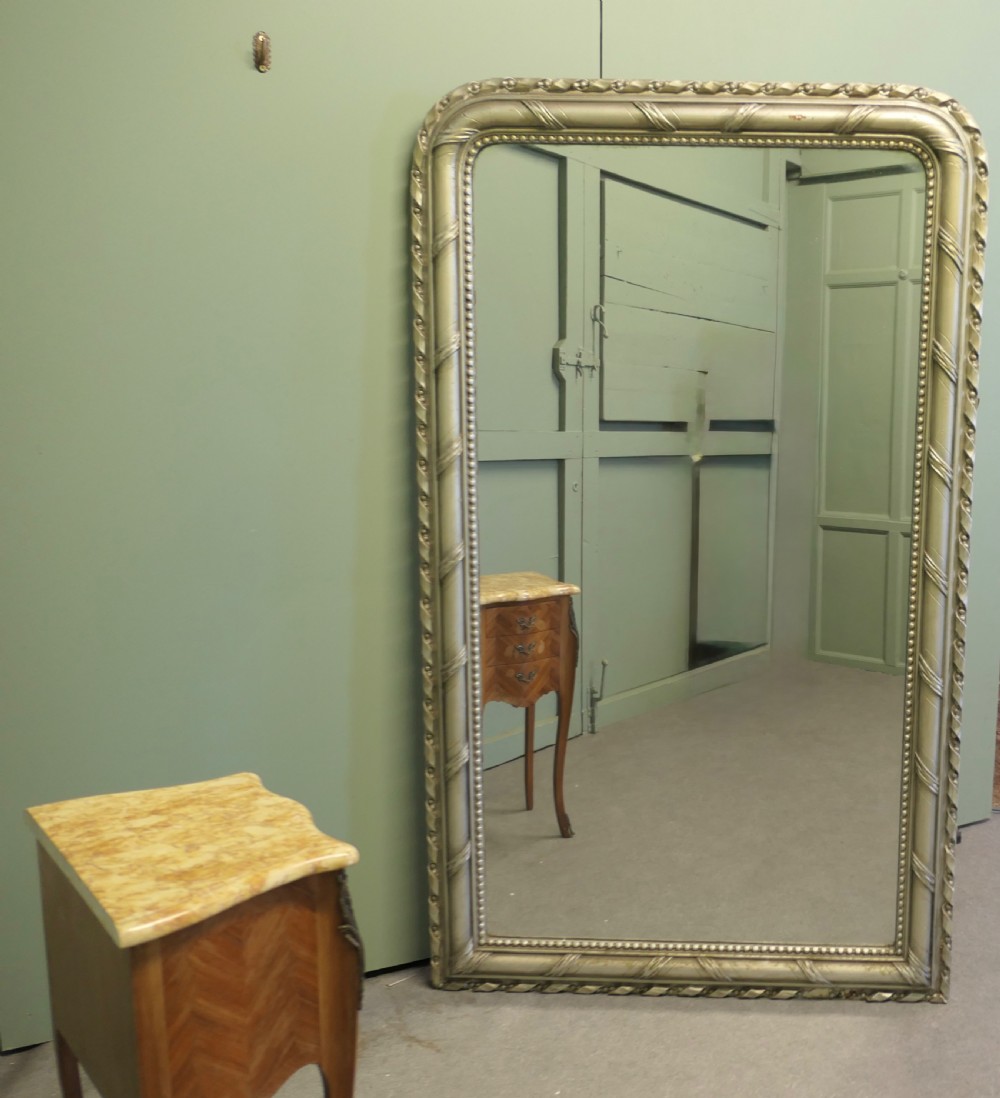 A tall French Louis Philippe mirror featuring a silver gilt frame with rounded upper corners, beaded inner trim, and rope moulding. View V