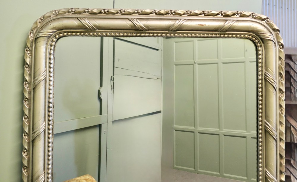 A tall French Louis Philippe mirror featuring a silver gilt frame with rounded upper corners, beaded inner trim, and rope moulding. View VI