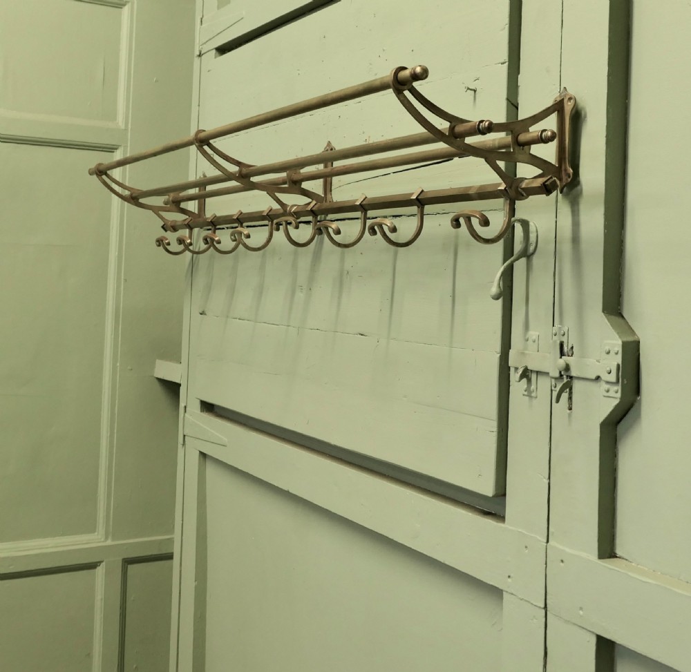 A 5ft French Art Deco brass wall-mounted hat and coat rack featuring an upper slatted shelf rail and eight sliding double hooks. View II
