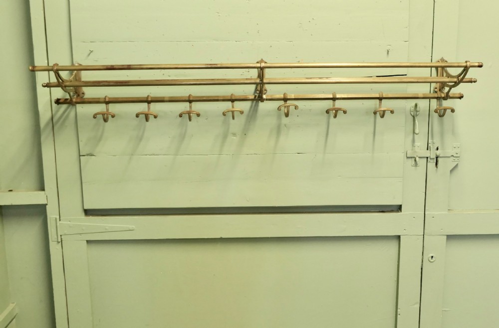 A 5ft French Art Deco brass wall-mounted hat and coat rack featuring an upper slatted shelf rail and eight sliding double hooks. View VI