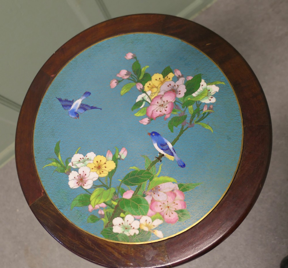 A small dark wood wine table featuring a carved pierced apron, turned pedestal column, and a circular light blue cloisonne top decorated with birds and flowers. View III