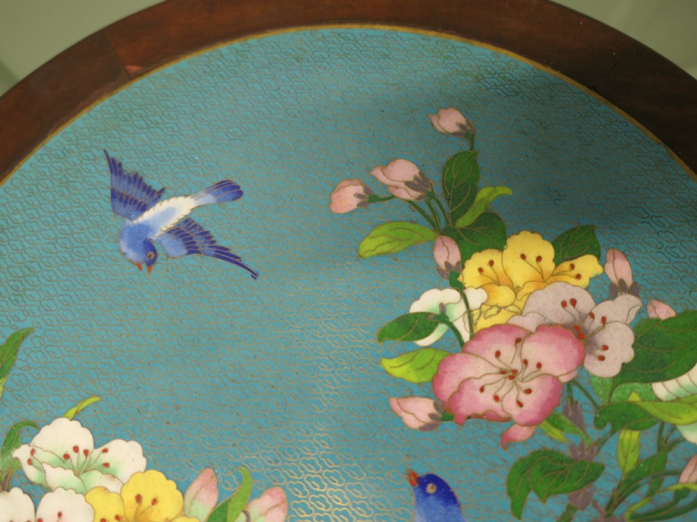 A small dark wood wine table featuring a carved pierced apron, turned pedestal column, and a circular light blue cloisonne top decorated with birds and flowers. View IV