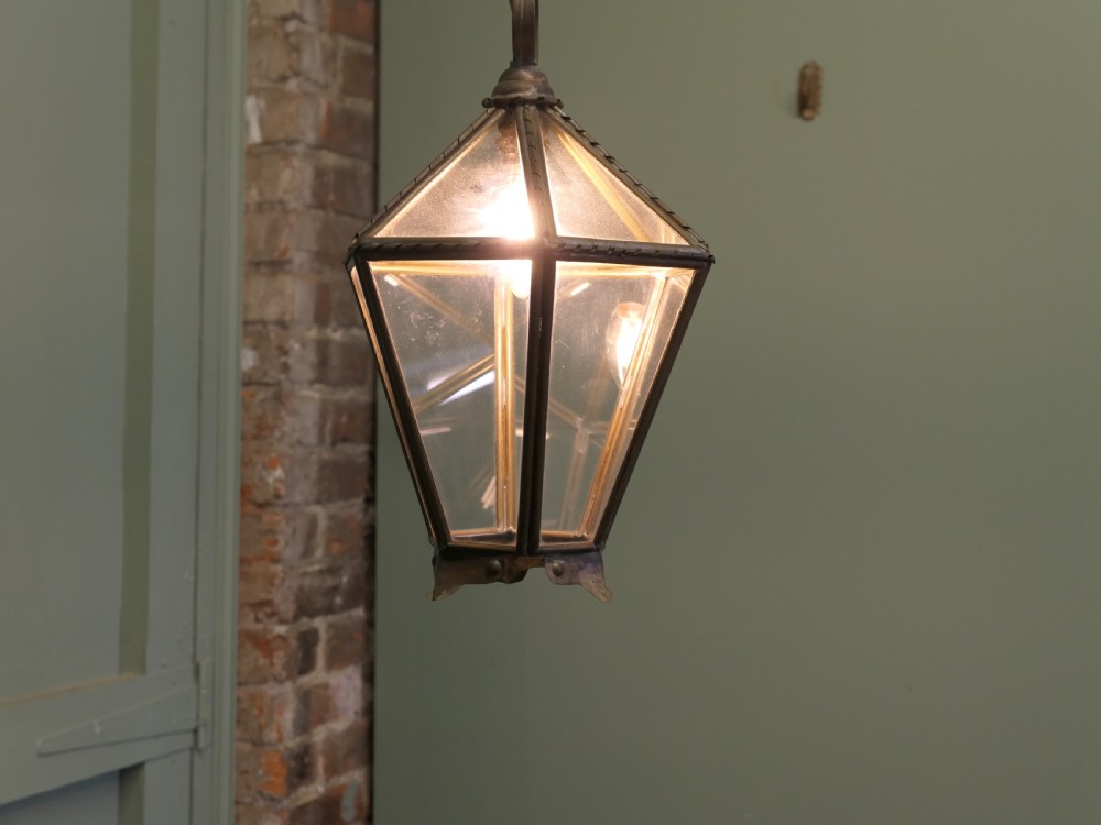 An Arts and Crafts brass hall lantern featuring faceted clear glass panels and a decorative chain hanging loop. View III