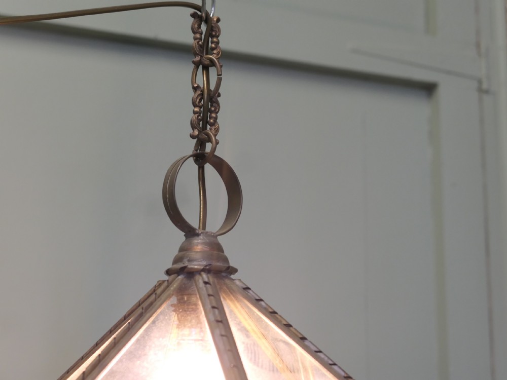 An Arts and Crafts brass hall lantern featuring faceted clear glass panels and a decorative chain hanging loop. View V
