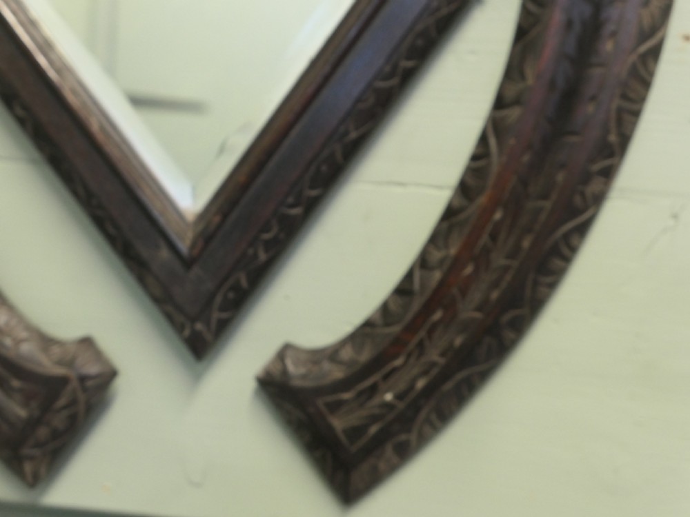 A dark carved oak horseshoe-shaped wall rack featuring five turned wooden coat pegs and a central diamond-shaped mirror. View III