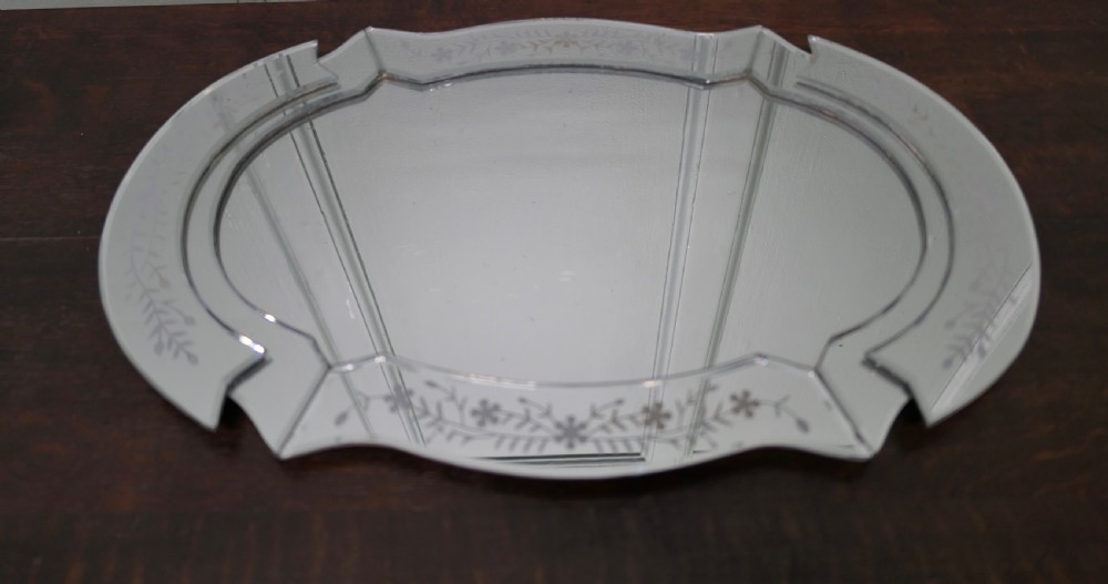 An Art Deco shaped mirrored glass tray featuring etched floral motifs and bevelled cut-glass borders.