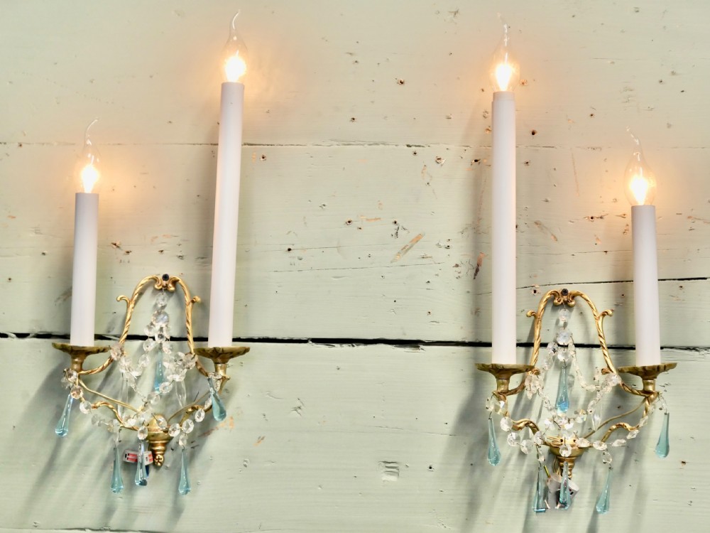 A pair of French gilt brass two-arm wall sconces decorated with clear and blue crystal glass droplets. View II