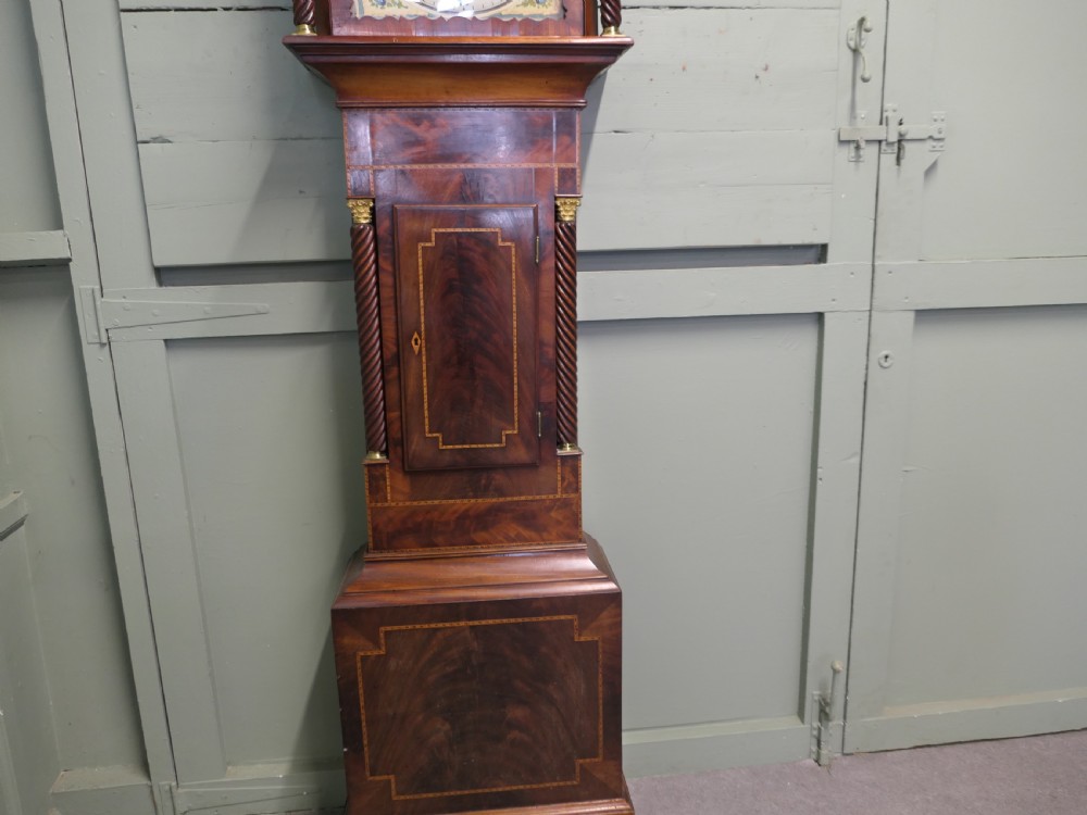 A Georgian mahogany longcase clock with a painted moonphase dial, twisted side columns, brass finials, and flame mahogany inlaid casing. View III