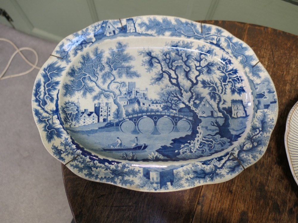 Pair of early nineteenth-century oval earthenware chargers featuring blue and white printed landscape and maritime motifs. View II
