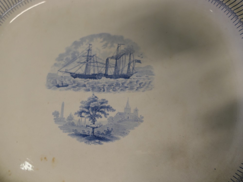 Pair of early nineteenth-century oval earthenware chargers featuring blue and white printed landscape and maritime motifs. View III