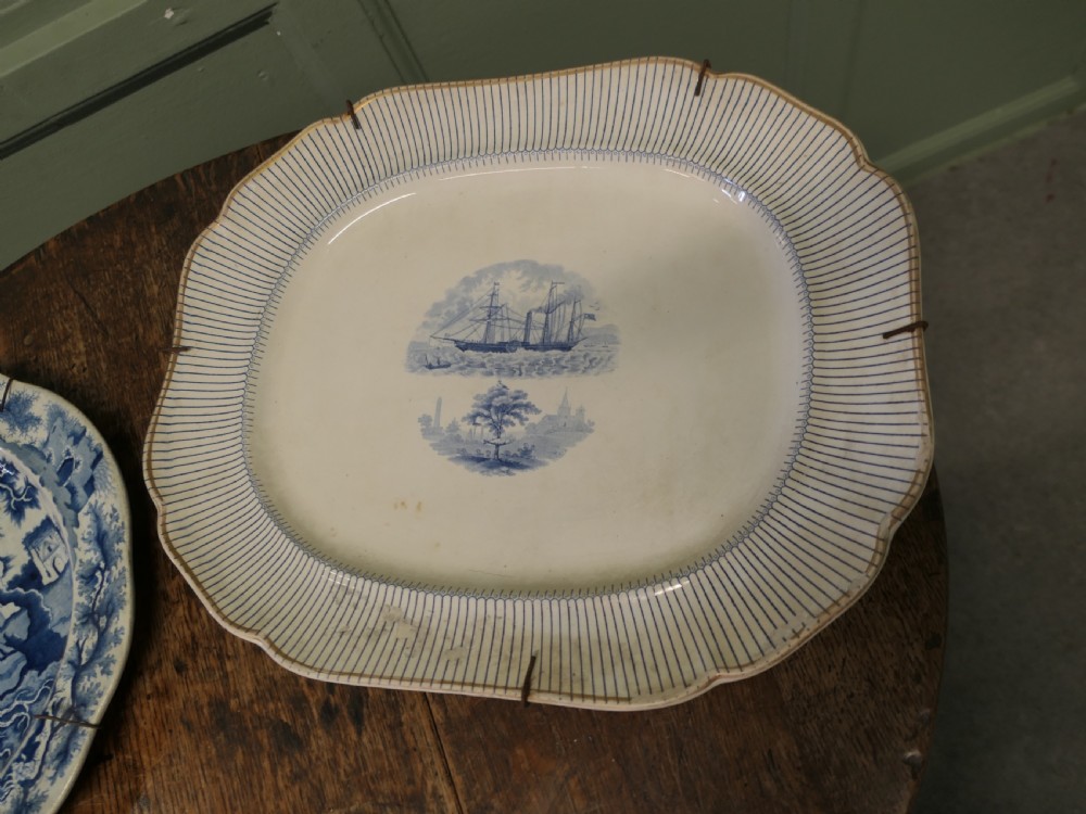 Pair of early nineteenth-century oval earthenware chargers featuring blue and white printed landscape and maritime motifs. View IV