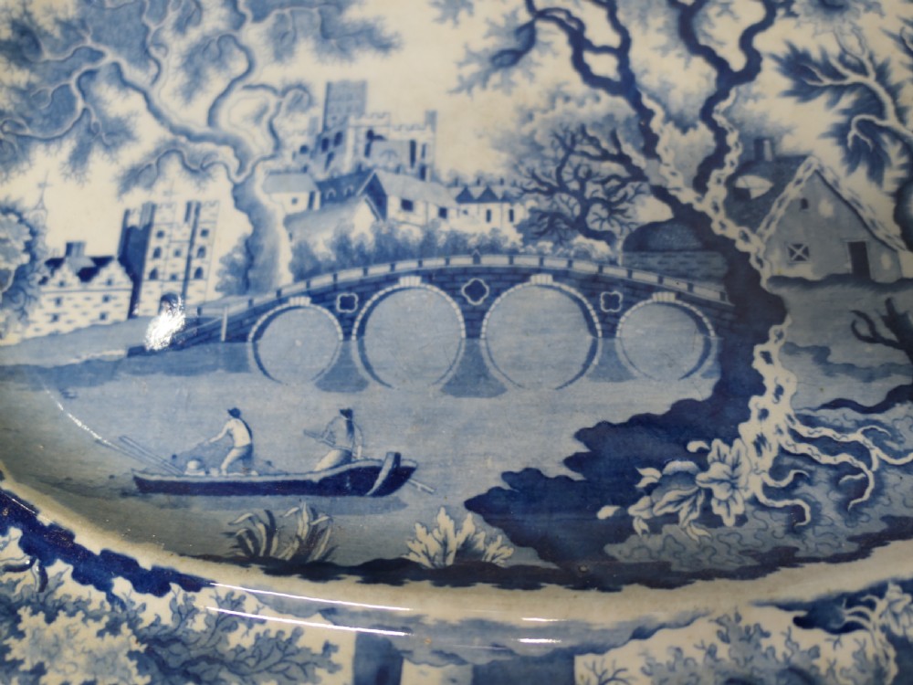 Pair of early nineteenth-century oval earthenware chargers featuring blue and white printed landscape and maritime motifs. View VI