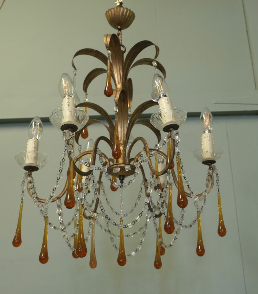 A French gilt metal toleware chandelier featuring curved foliage branches, candle-style bulb holders, clear beaded swags, and suspended amber glass teardrops. View VII