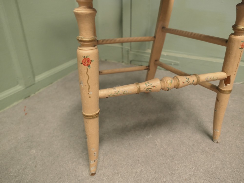 A Victorian painted balloon back bedroom chair featuring a cream frame with hand-painted floral motifs and a woven cane seat. View II