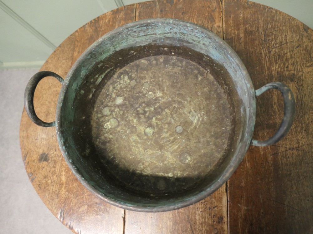 A large 19th-century copper preserving pan featuring twin riveted handles and a patinated finish with hints of verdigris. View VI