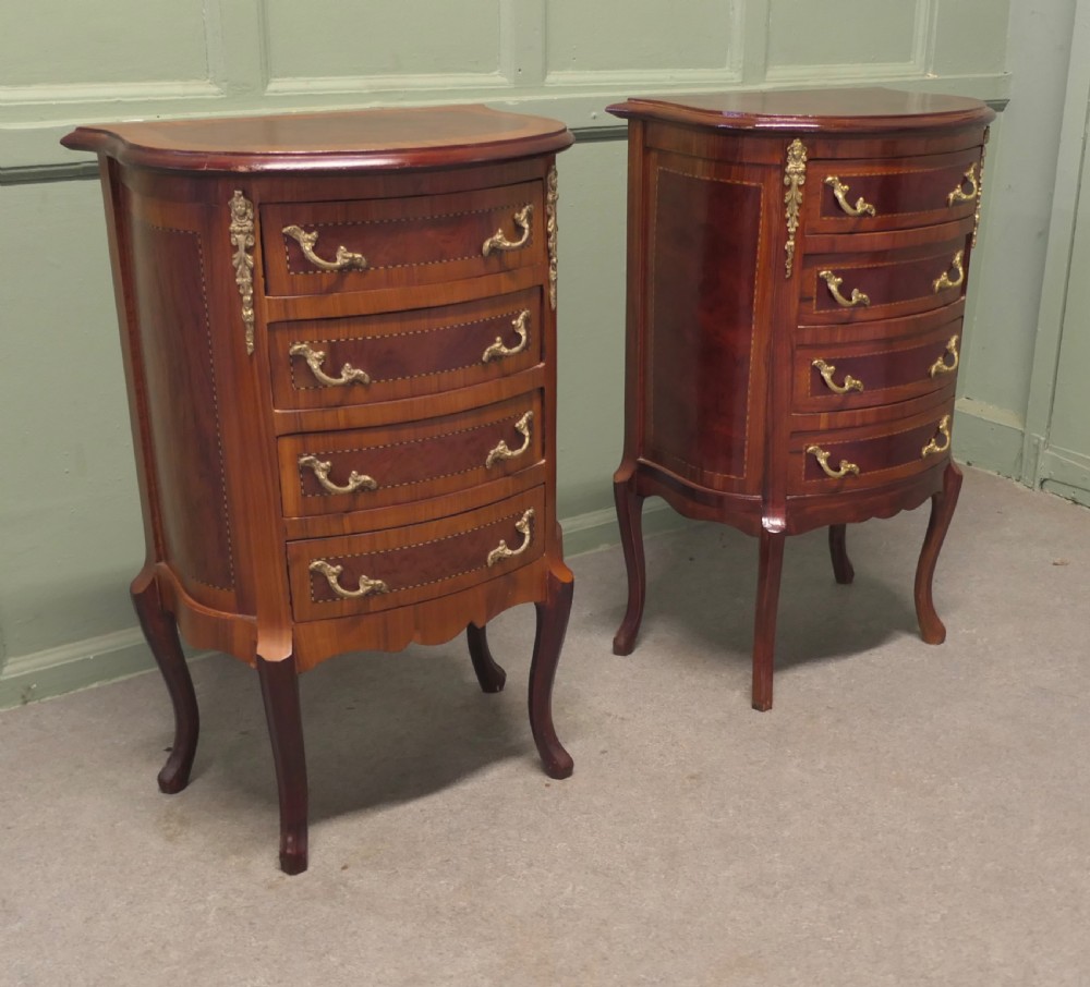 A near pair of French Louis XV style bow-front wooden bedside cabinets with four drawers, brass handles, and cabriole legs.