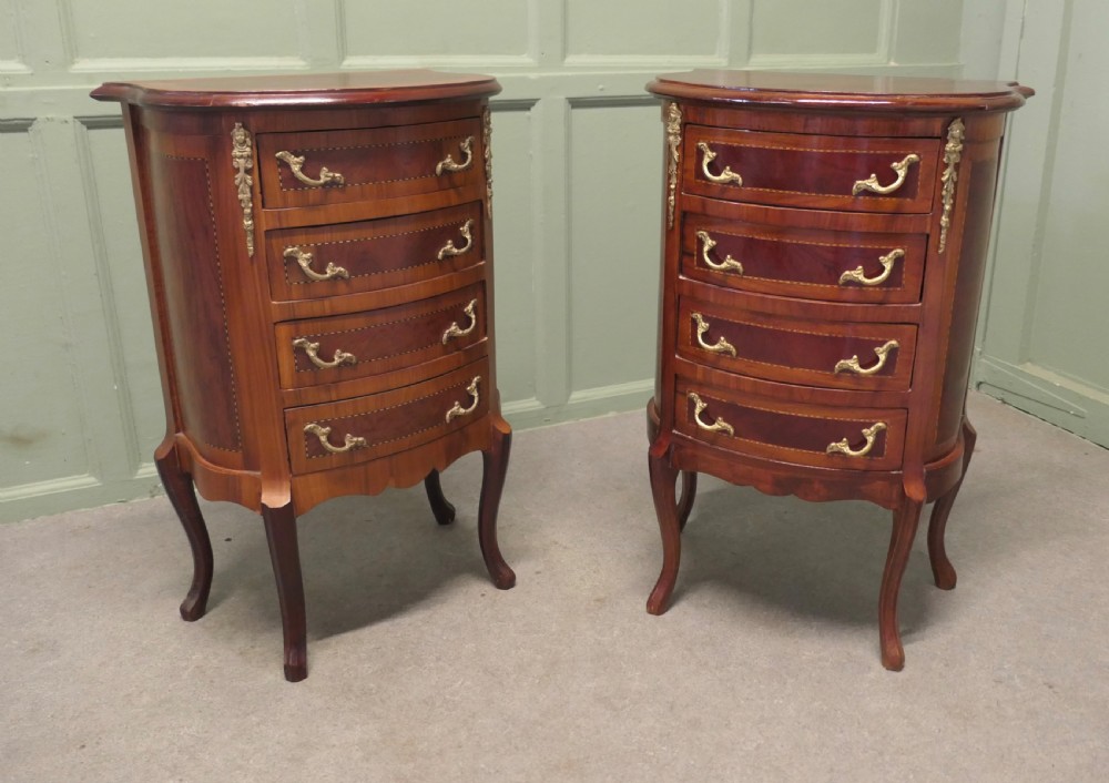 A near pair of French Louis XV style bow-front wooden bedside cabinets with four drawers, brass handles, and cabriole legs. View V