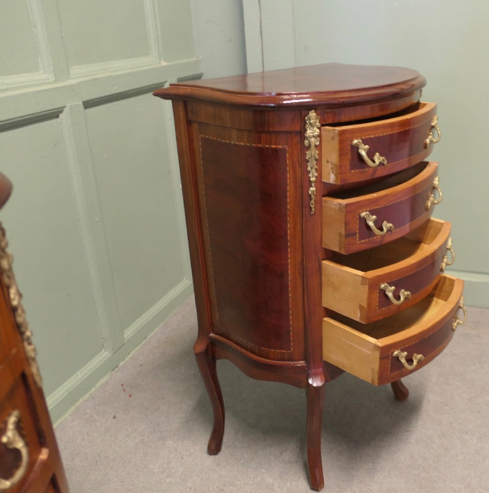 A near pair of French Louis XV style bow-front wooden bedside cabinets with four drawers, brass handles, and cabriole legs. View VI