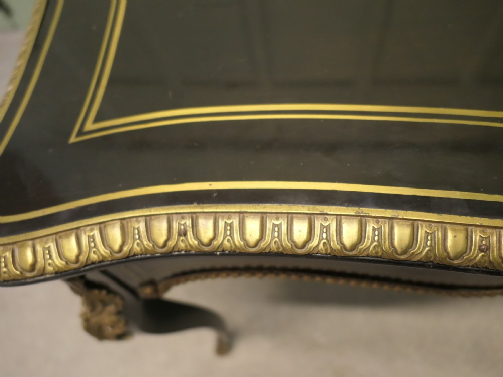A French Louis XV style ebonised games table featuring brass inlay, decorative ormolu mounts, and slender cabriole legs. View II