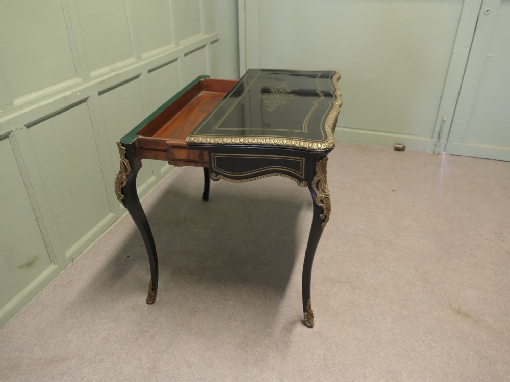 A French Louis XV style ebonised games table featuring brass inlay, decorative ormolu mounts, and slender cabriole legs. View III