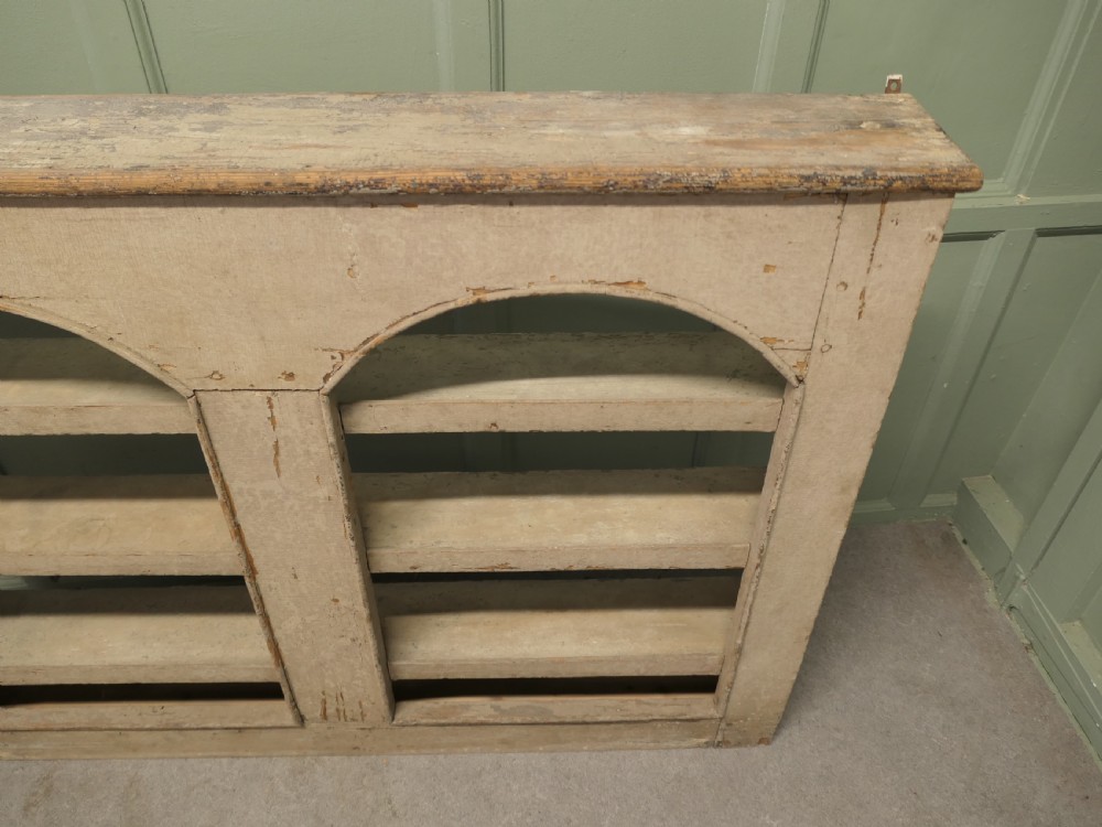 An early 19th-century French pine alcove shelving unit featuring two arched open bays, horizontal interior shelves, and a distressed cream painted finish. View III