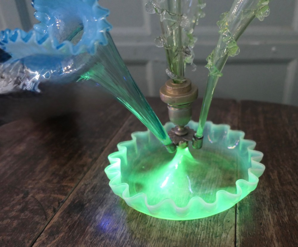 A light green uranium and opalescent glass epergne featuring three trumpet-shaped flower holders with crimped rims set above a ruffled glass dish base. View IV