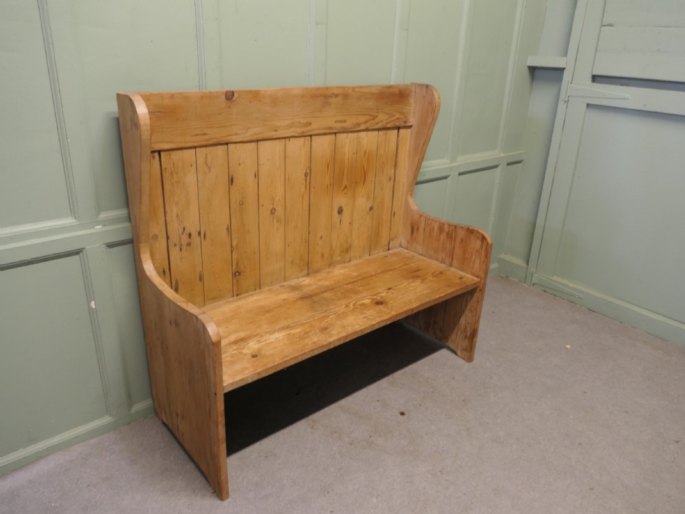 A high-back rustic pine settle bench featuring vertical planking and solid side armrests in a natural warm wood finish. View IV