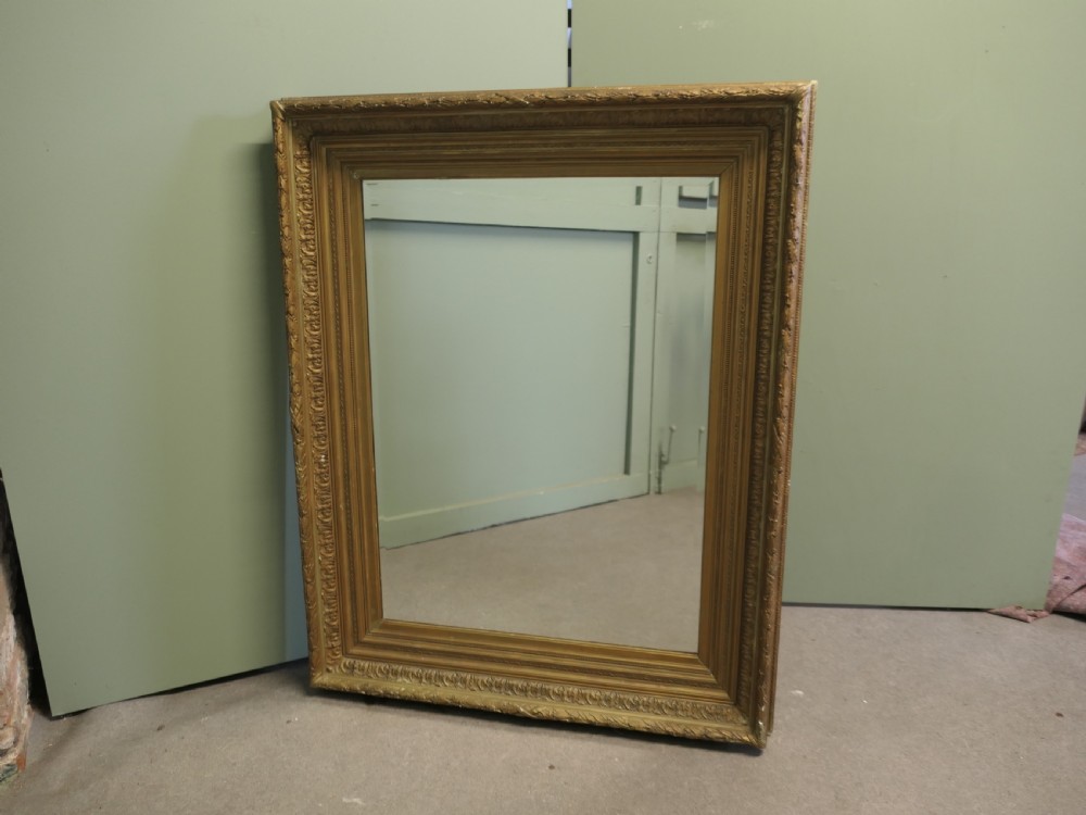 A large nineteenth-century rectangular wall mirror featuring a heavily moulded giltwood frame with classic border detailing.