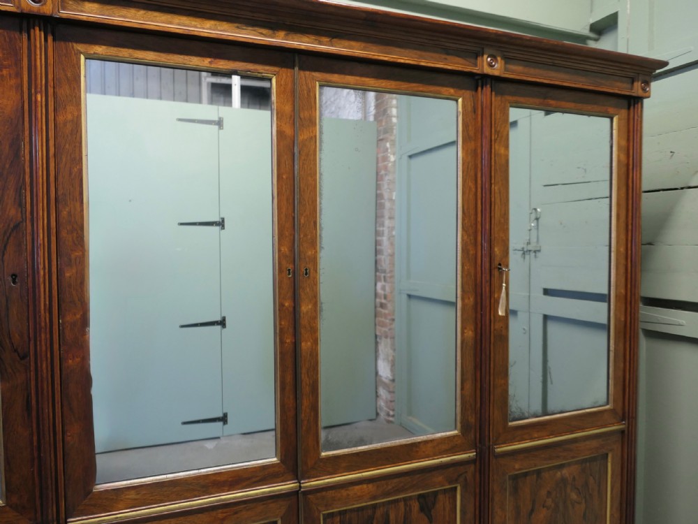 A nineteenth-century Regency rosewood four-door wardrobe with mirrored upper sections and brass stringing decoration. View III