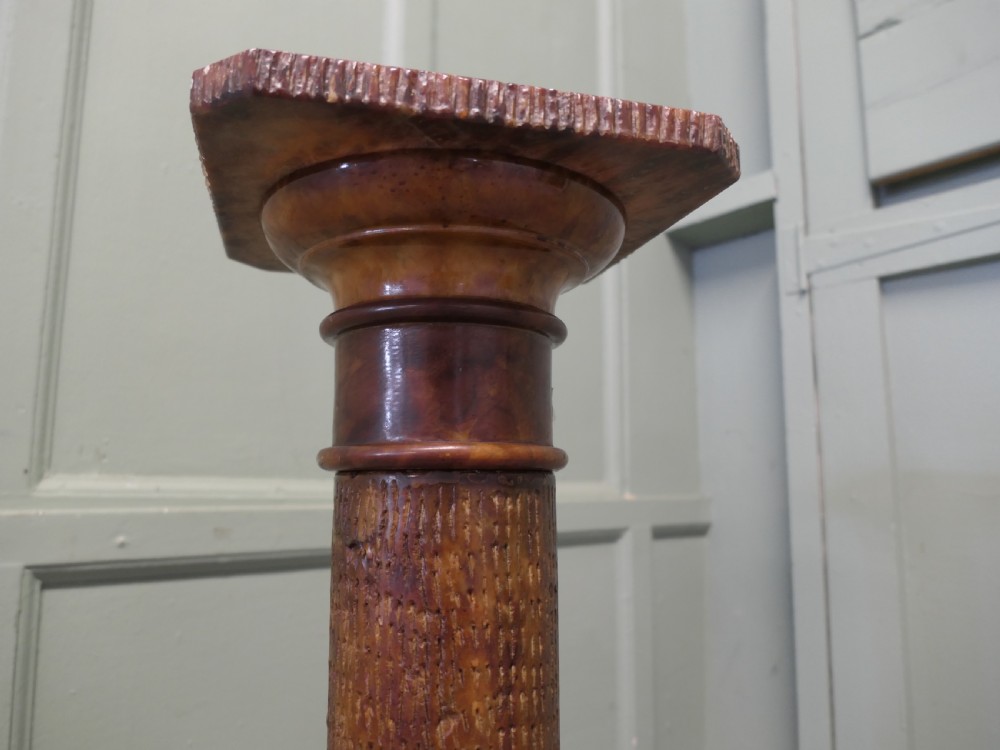 A tall honey-coloured marble pedestal column featuring a flat top surface, turned shaft with raised ring mouldings, and a heavy circular base. View IV