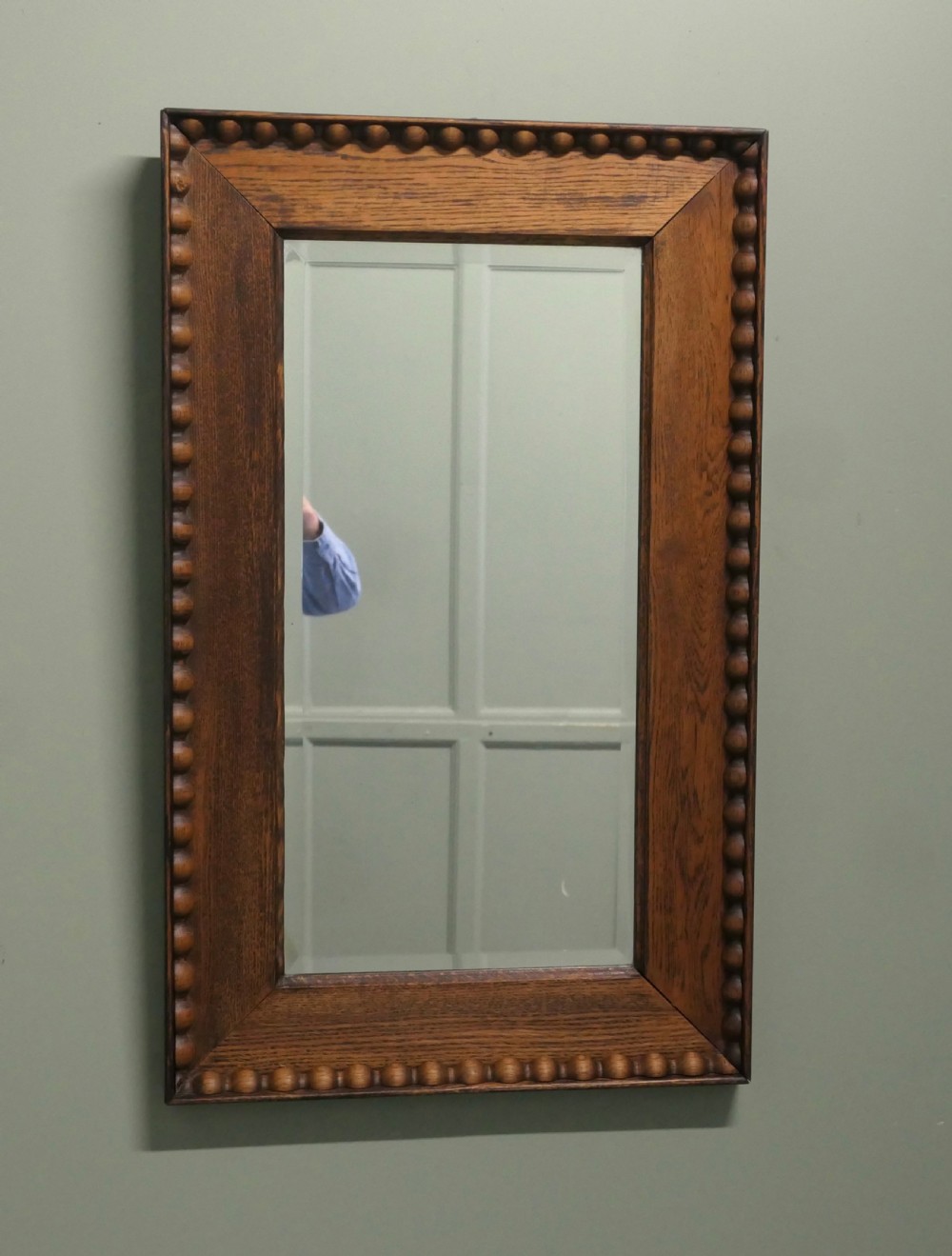 A rectangular Victorian golden oak wall mirror featuring a carved beaded outer border and mitred frame corners. View III