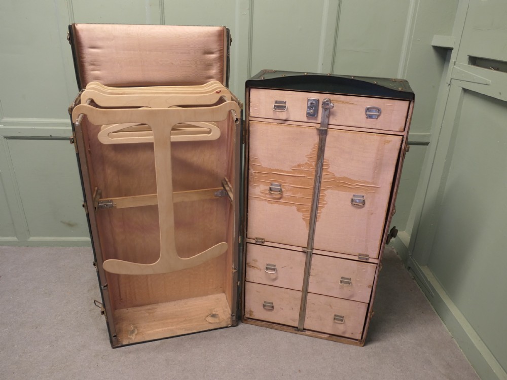 A tall, upright dark green French steamer wardrobe trunk with brass corner braces, studded trim, and side leather handles. View II