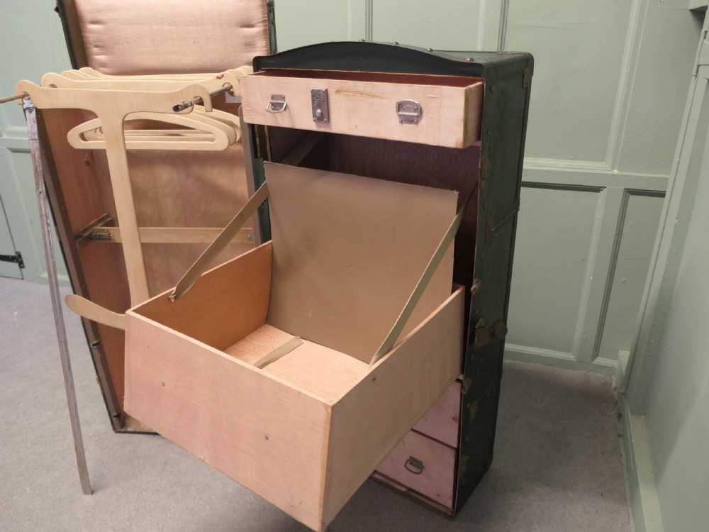 A tall, upright dark green French steamer wardrobe trunk with brass corner braces, studded trim, and side leather handles. View III