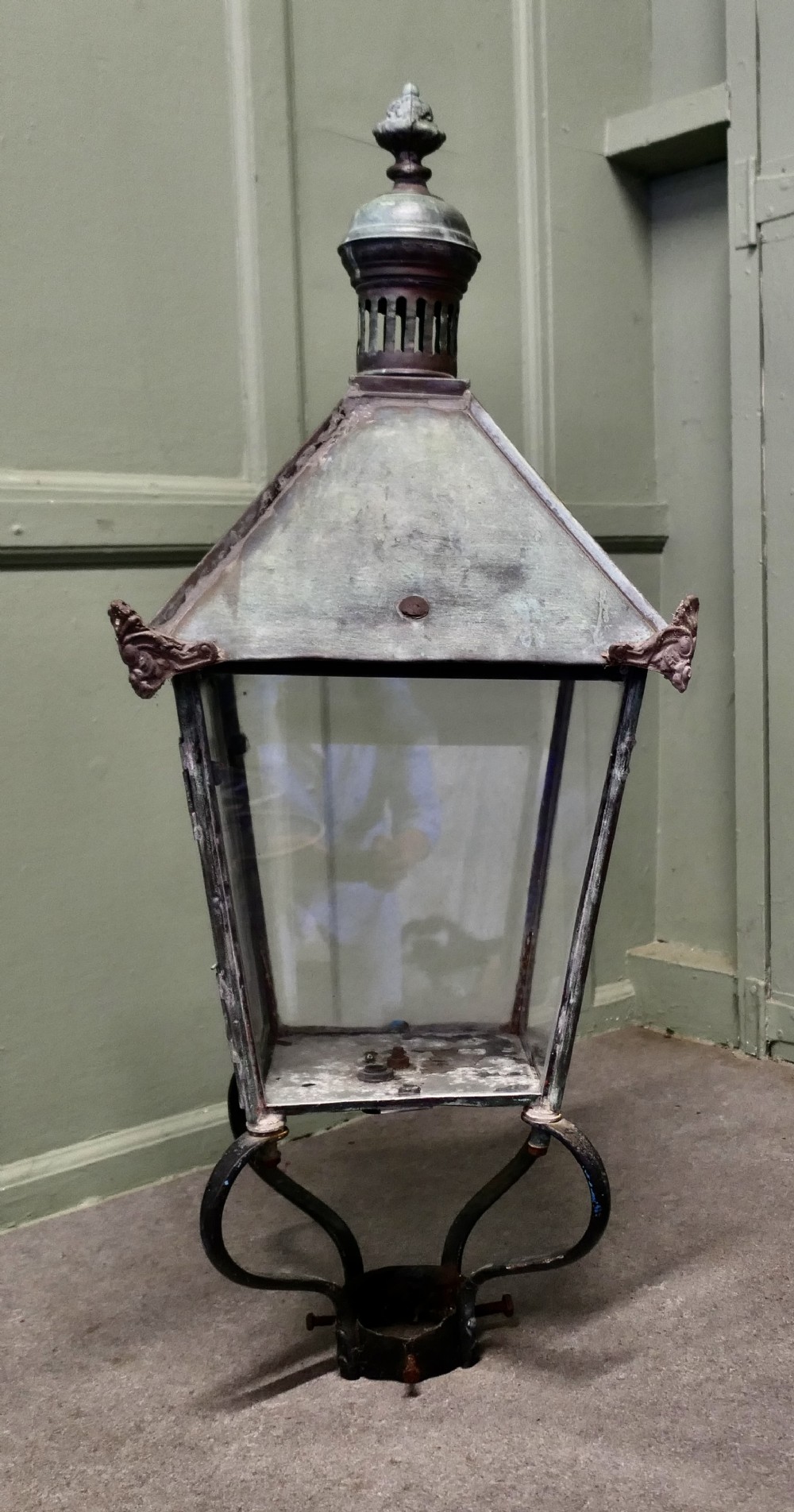 A large mid-19th century copper street lantern featuring clear glass panes, a tapered body, a pierced chimney cap with decorative finial, and a wrought iron post mount with verdigris patina.