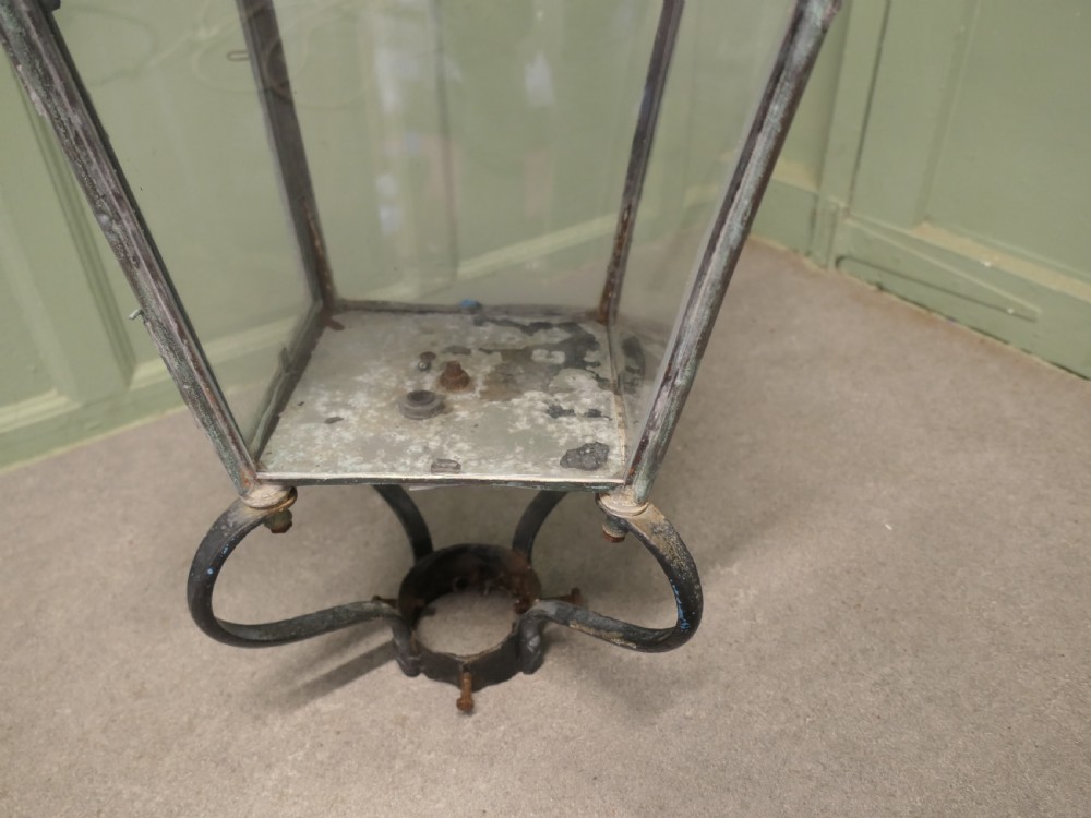 A large mid-19th century copper street lantern featuring clear glass panes, a tapered body, a pierced chimney cap with decorative finial, and a wrought iron post mount with verdigris patina. View VI