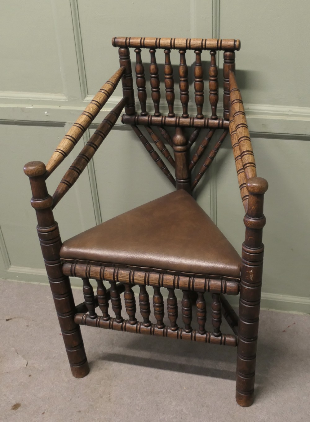 A 19th-century oak turners armchair featuring extensive bobbin-turned spindles, a triangular leather seat with stud detailing, and turned legs. View VI