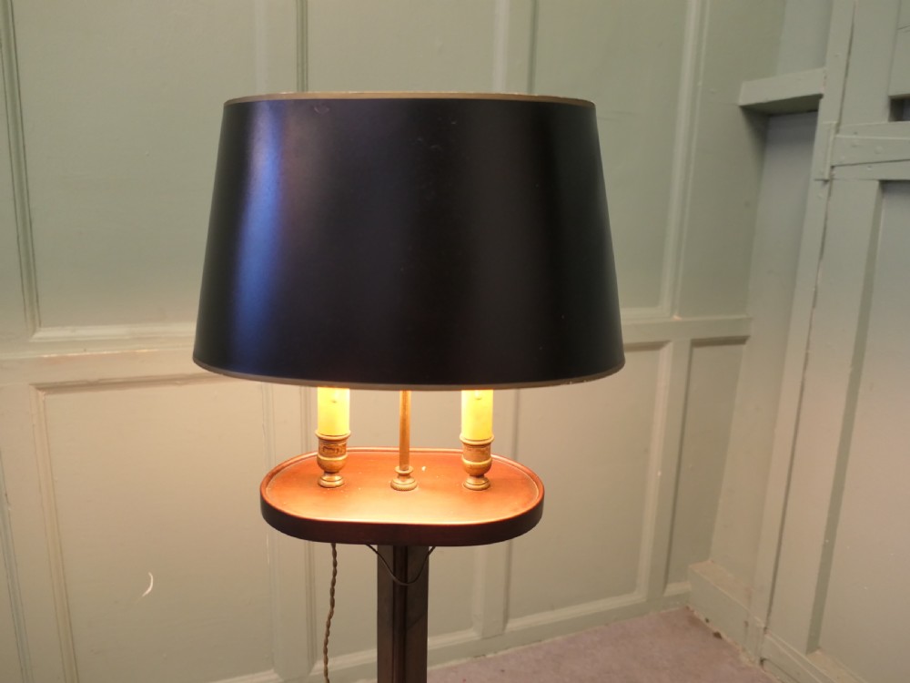 An antique mahogany bouillotte floor lamp featuring a dark oval shade mounted over twin faux-candle sockets on a tripod base. View III