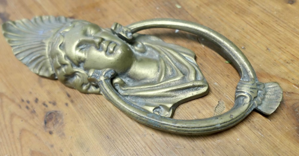 A cast brass Victorian door knocker featuring a classical female bust with a fan motif crown and an articulated oval ring. View II