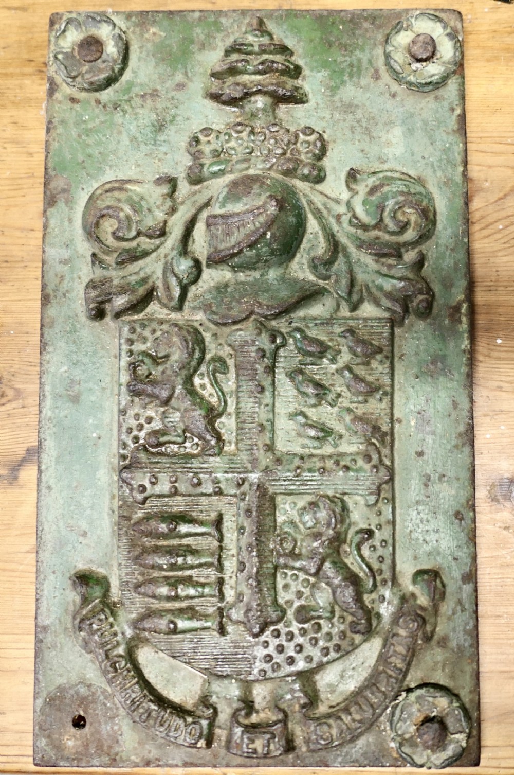 A rectangular cast iron wall plaque featuring the relief-moulded Bournemouth coat of arms with weathered green paint and visible oxidisation.