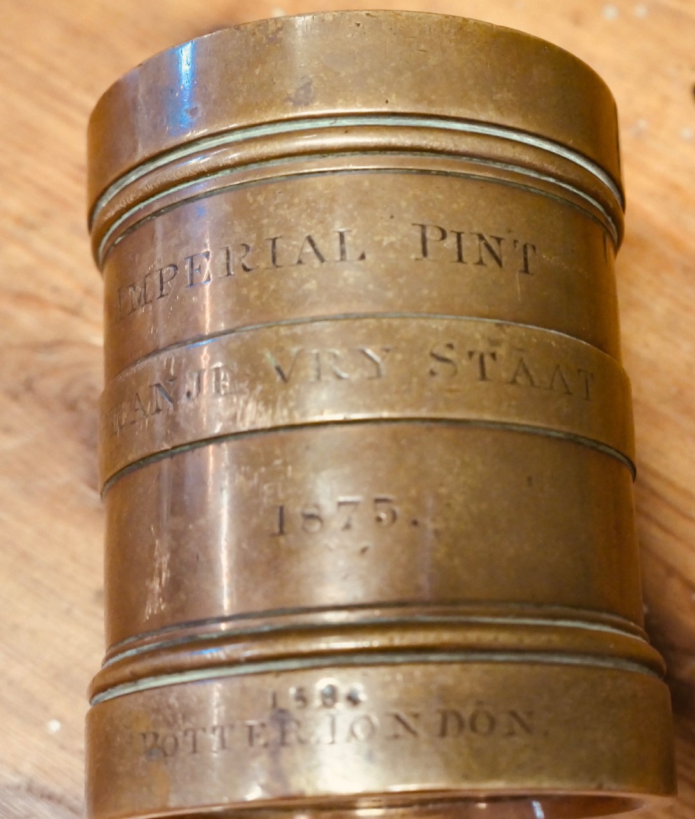 A cylindrical nineteenth-century cast bronze imperial pint measure with engraved lettering and official verification stamps. View IV