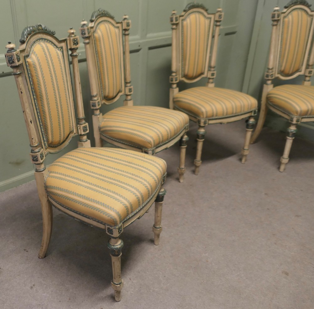 A set of four antique French salon chairs featuring carved cream and green painted frames with yellow and cream striped fabric upholstery. View VI