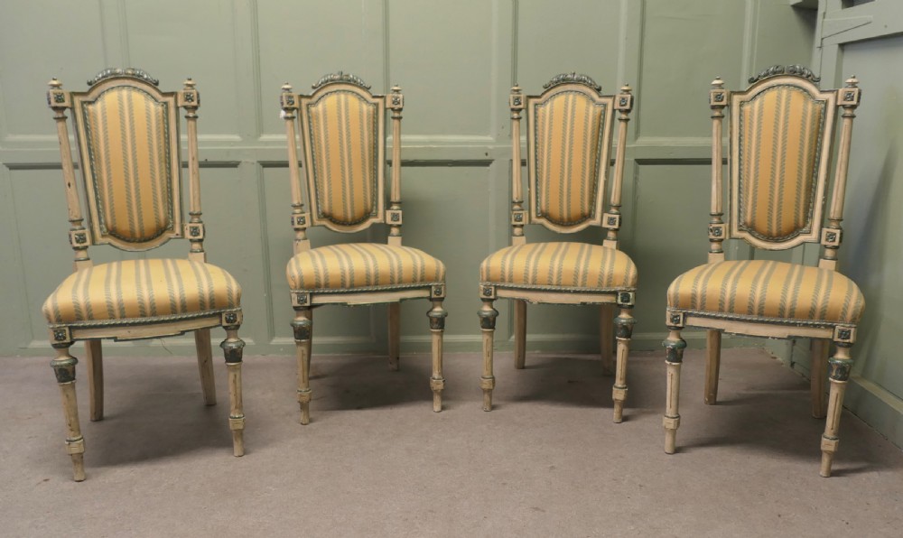 A set of four antique French salon chairs featuring carved cream and green painted frames with yellow and cream striped fabric upholstery. View IX