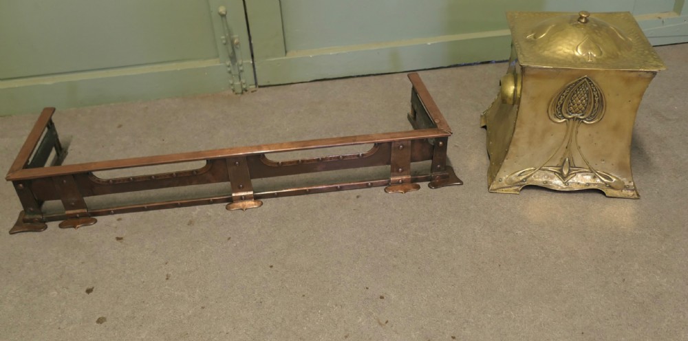 A 19th-century copper fireplace fender with hand-riveted joinery, a hammered metal texture, and raised rectangular rails. View VI