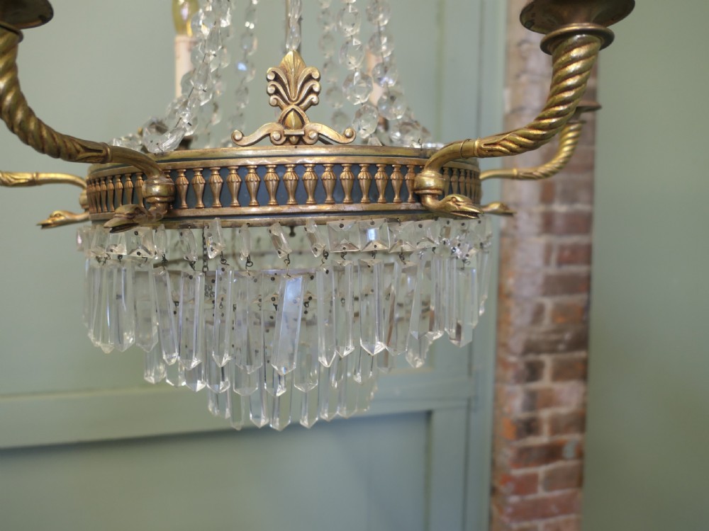 A French Empire style six-branch chandelier featuring a crystal bead tent structure, central brass band with outward-extending scroll arms, and cascading crystal waterfall drops. View V