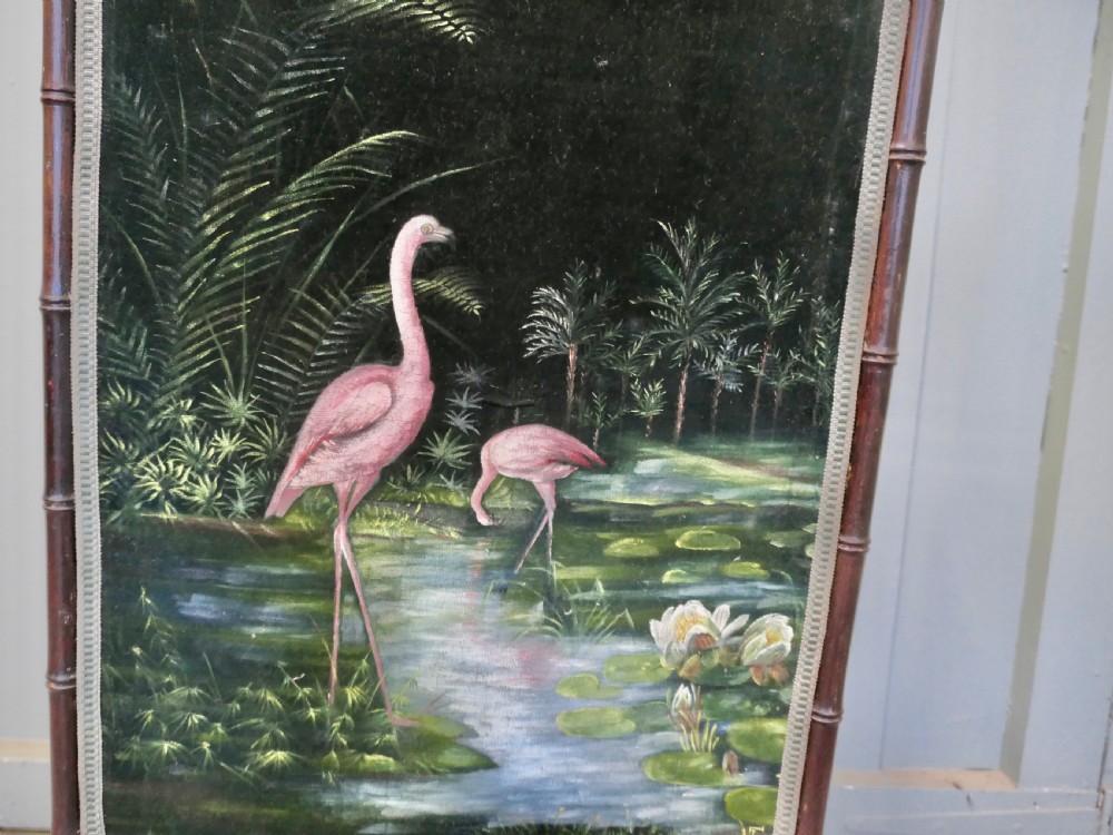 A dark lacquered wooden fire screen with a faux bamboo frame displaying a painted central panel depicting two flamingos in a tropical marshland. View II
