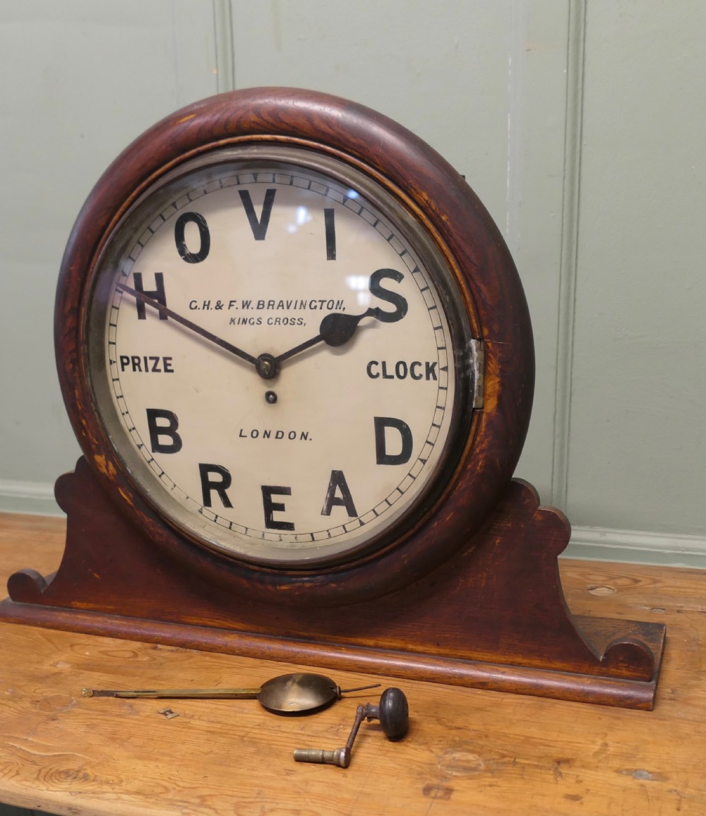 An Edwardian dark wood mantel clock featuring a round cream dial printed with Hovis Bread typography. View II