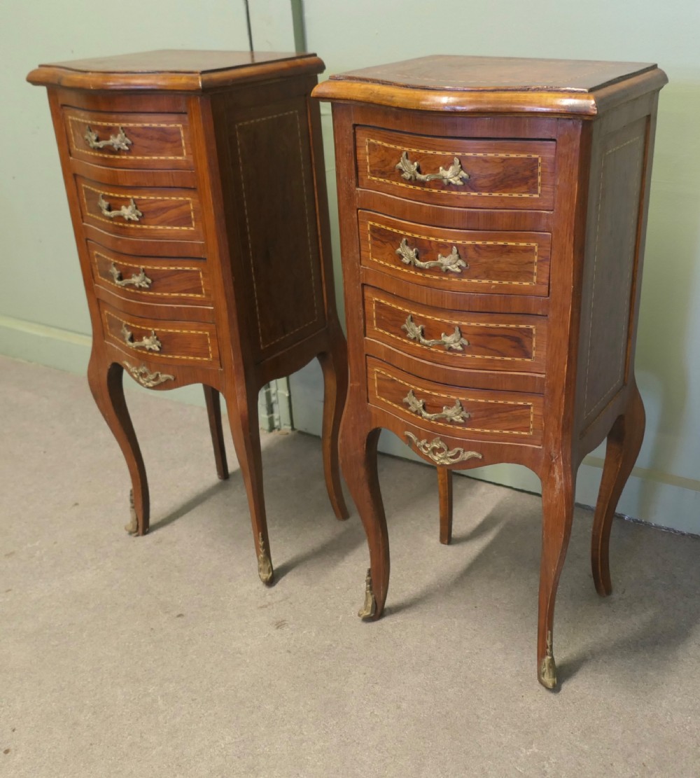 A pair of tall French walnut bedside lockers featuring four inlaid drawers, curved cabriole legs, and gilded brass ormolu mounts. View II